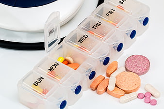 Weekly pill organizer with assorted medication and stethoscope