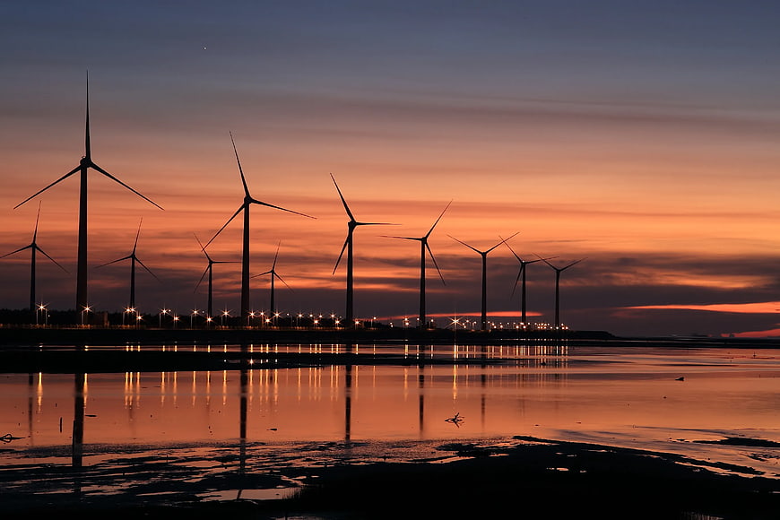Wind Turbines Silhouette at Sunset with Water Reflection