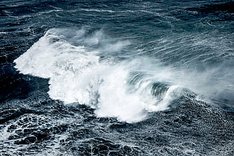 Powerful ocean wave crashing with white foam spray