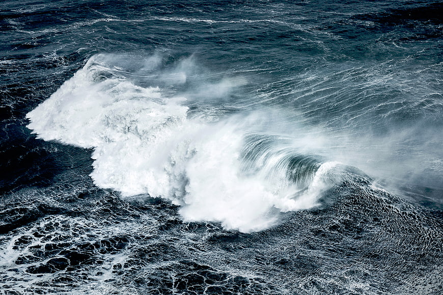 Powerful ocean wave crashing with white foam spray