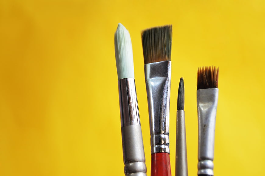 Close-up of paintbrushes on yellow background