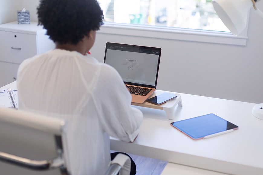 Woman working on laptop in bright modern office workspace