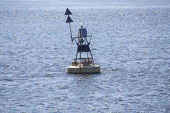 Navigation buoy floating on shimmering blue water