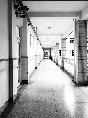 Black and white perspective of an empty school corridor