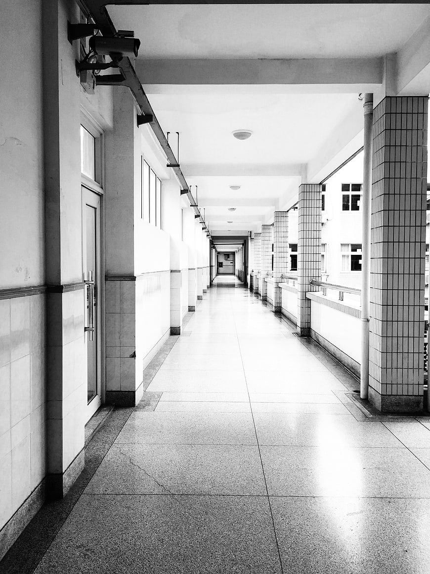 Black and white perspective of an empty school corridor