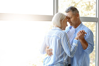Senior couple dancing romantically by a bright window