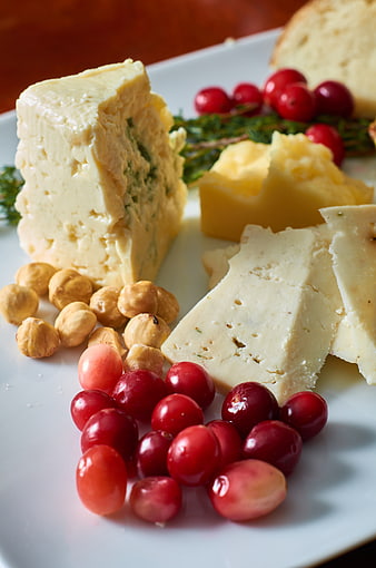 Gourmet cheese platter with grapes, hazelnuts, and bread
