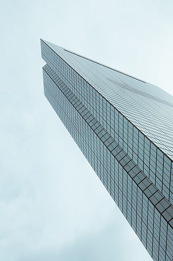 Low angle view of modern glass skyscraper against sky