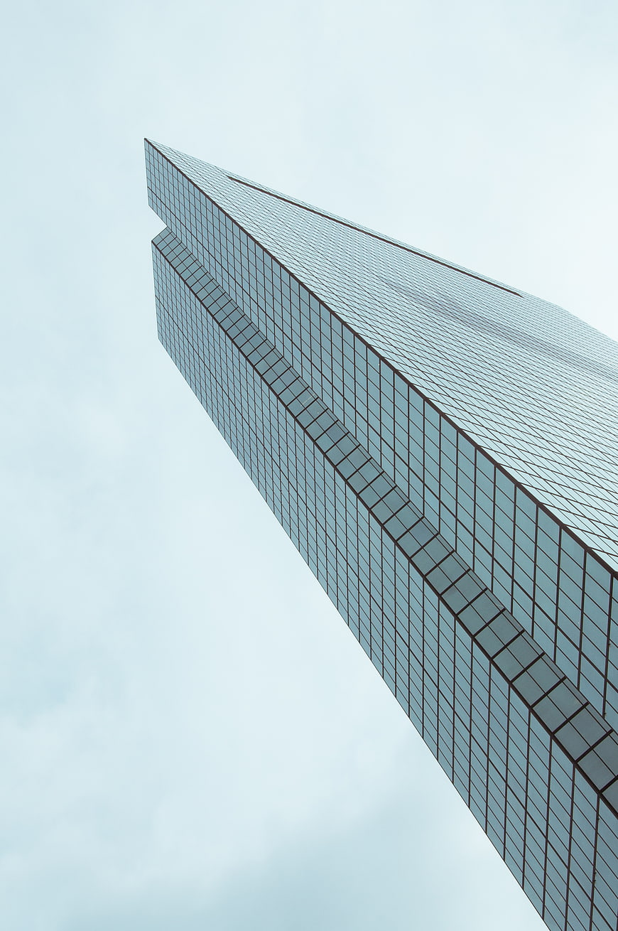 Low angle view of modern glass skyscraper against sky