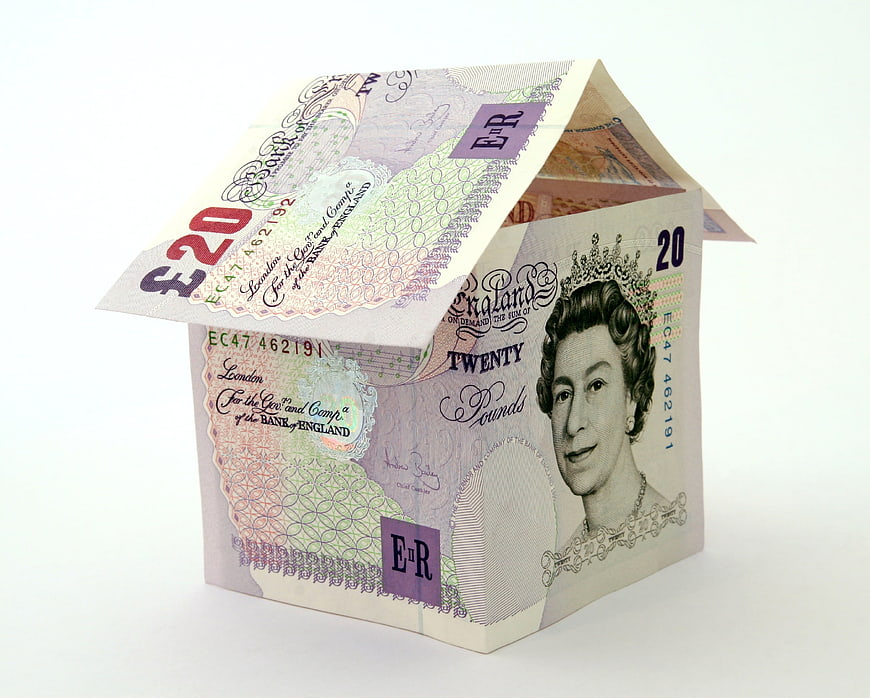 House made of British twenty pound banknotes on white background