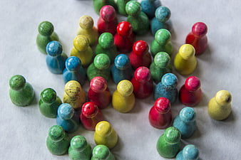 Colorful Wooden Human Figures Grouped Together on White Surface