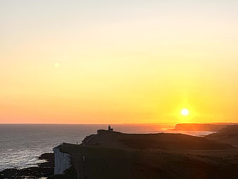 Sunset over white cliffs and lighthouse coastal landscape
