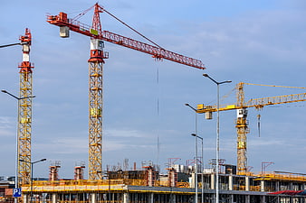 Construction site with multiple tower cranes against blue sky
