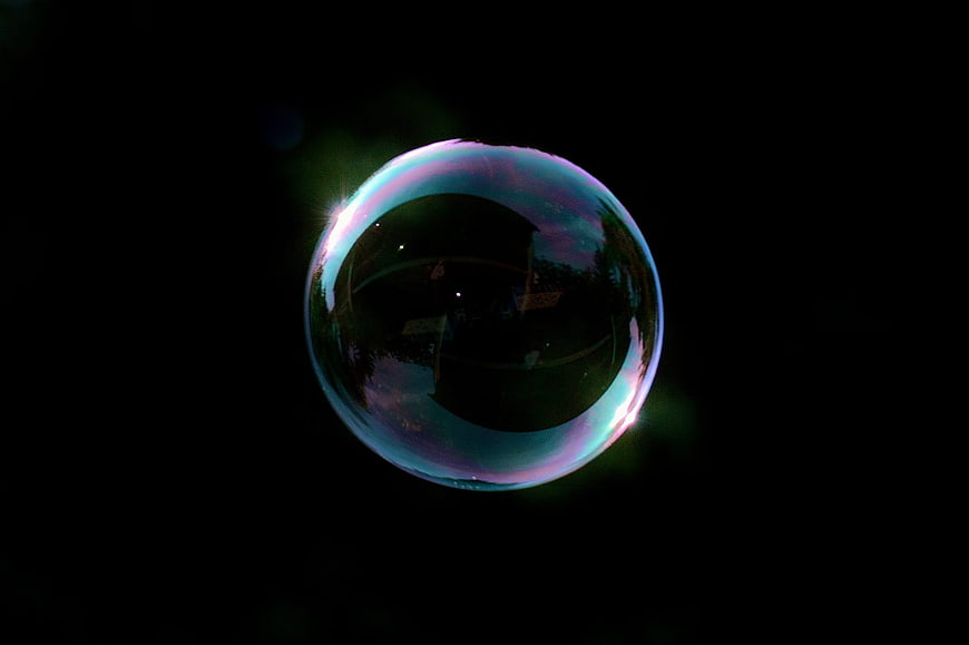Iridescent Soap Bubble Floating Against Black Background