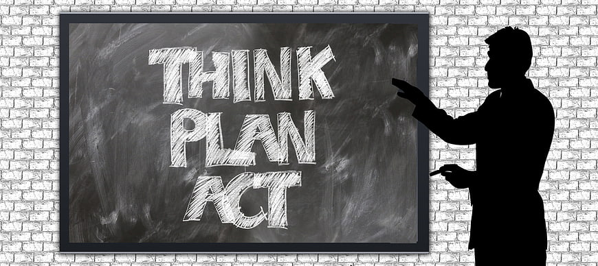 Silhouette of man pointing at chalkboard with think plan act text