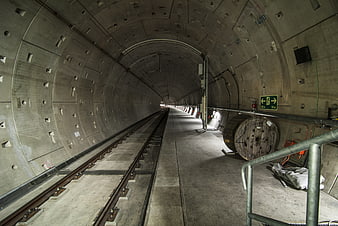 Concrete railway tunnel with tracks and construction equipment