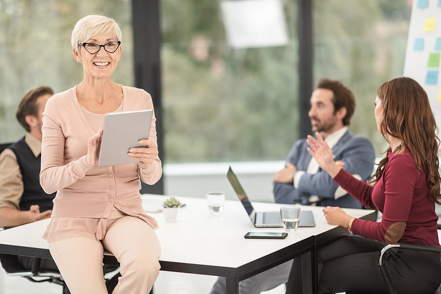 Senior Businesswoman with Tablet in Office Meeting