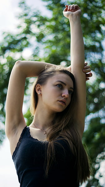 Young woman stretching arms outdoors in nature