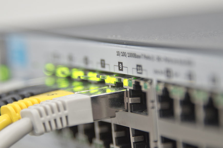 Close-up of yellow ethernet cable plugged into network switch port
