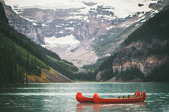 Red Canoe on Turquoise Mountain Lake with Snowy Peaks