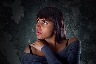 Portrait of Woman Looking Up Against Dark Textured Wall