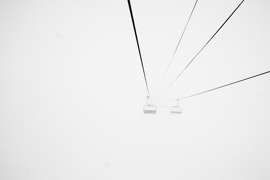 Minimalist Ski Lift Chairs in Heavy Fog