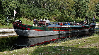Vintage green canal boat with passengers in autumn