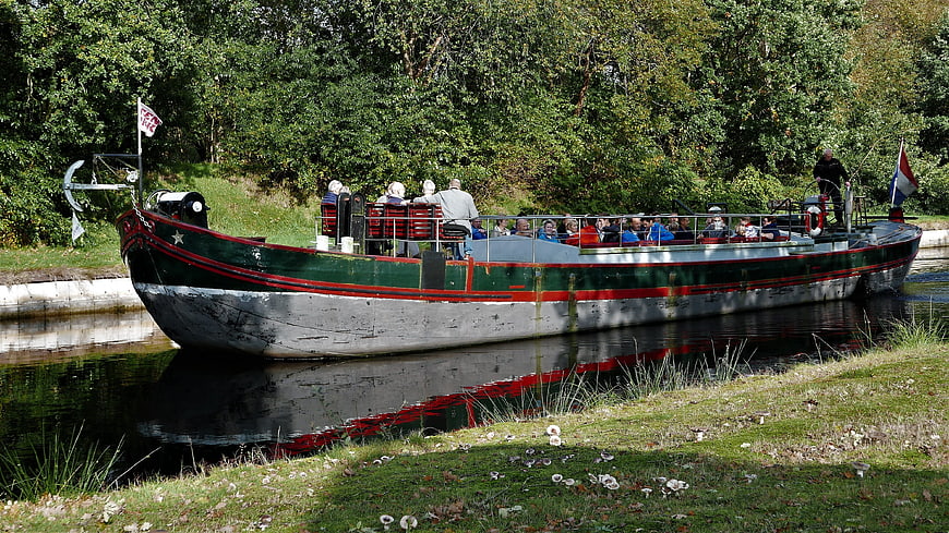 Vintage green canal boat with passengers in autumn