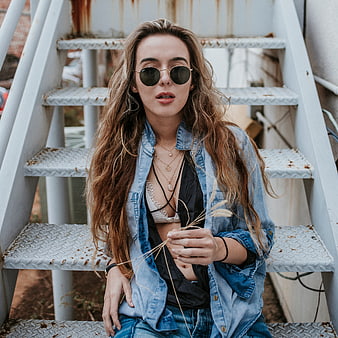 Stylish Woman in Denim Jacket Sitting on Metal Stairs