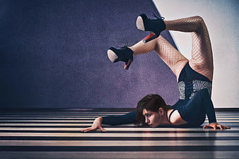 Woman in Fishnets Performing Extreme Backbend on Striped Floor