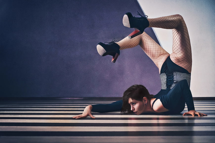 Woman in Fishnets Performing Extreme Backbend on Striped Floor