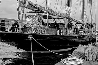 Black and white photo of a classic sailing yacht docked at a marina