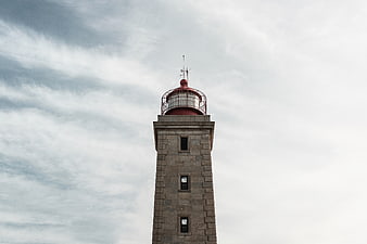 Stone Lighthouse Tower Against Cloudy Sky