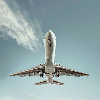 Low Angle View of Airplane Underbelly in Blue Sky