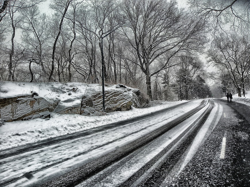 Snowy Road in Central Park with Walking Silhouettes