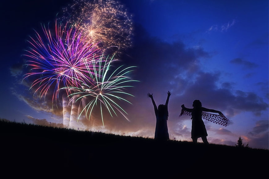 Silhouettes of Two Girls Watching Fireworks at Night