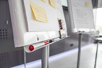 Close-up of whiteboard with sticky notes and markers in office
