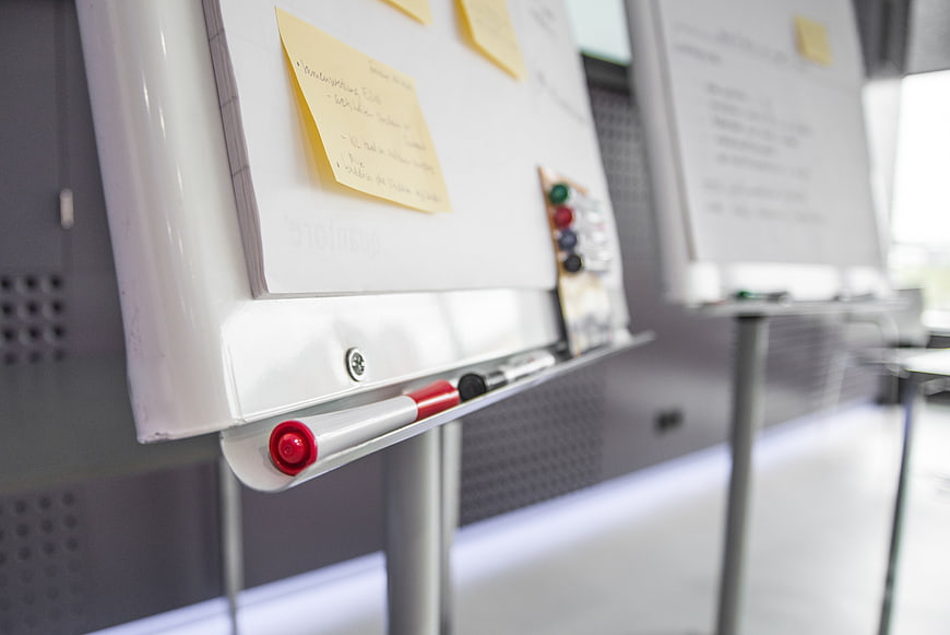 Close-up of whiteboard with sticky notes and markers in office