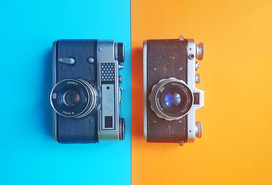 Two vintage film cameras on split blue and yellow background