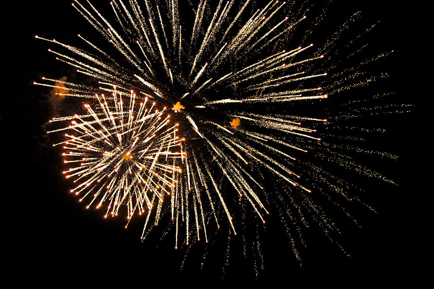 Golden fireworks exploding in the night sky