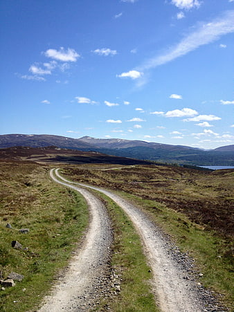 Winding Gravel Road Through Scottish Highlands Landscape