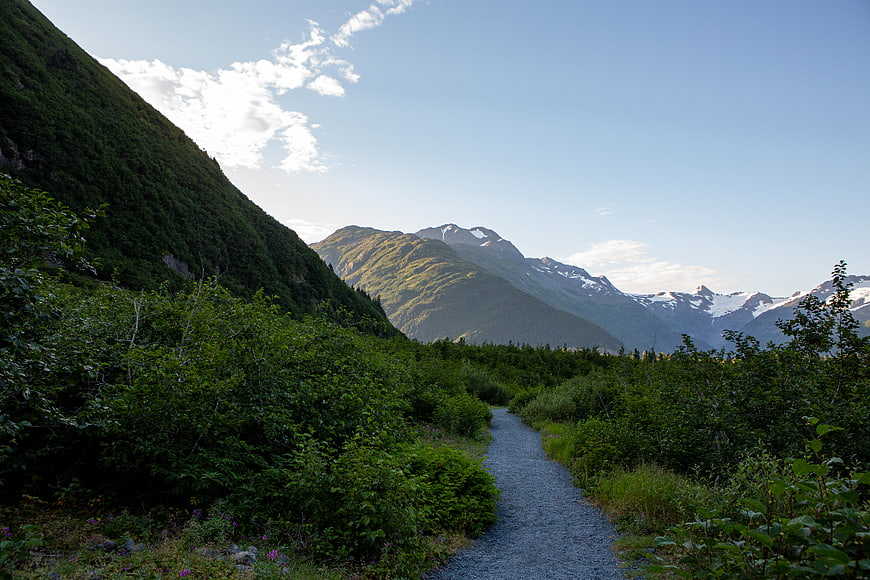 Gravel hiking trail winding through lush green mountains