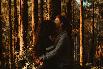 Romantic couple kissing in a sunlit forest