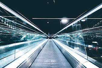 Futuristic moving walkway with light trails in modern architecture