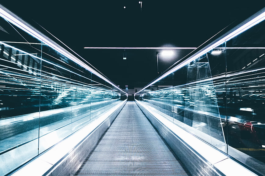 Futuristic moving walkway with light trails in modern architecture