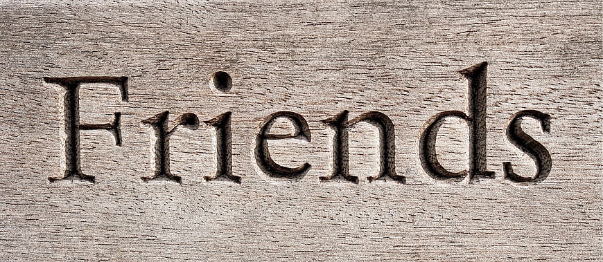 Word Friends Carved into Weathered Wood Texture