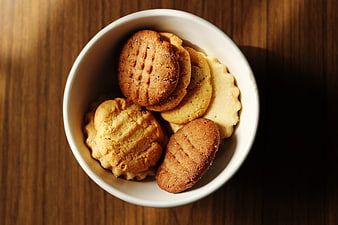 Top View of Assorted Cookies in White Bowl on Wood
