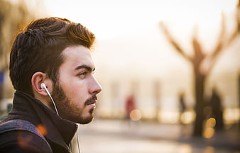 Young man with headphones listening to music outdoors