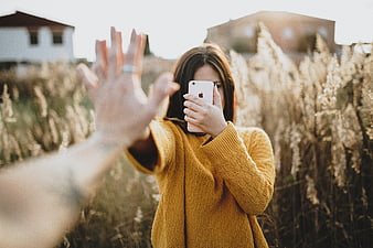 Woman in Yellow Sweater Blocking Camera in Field