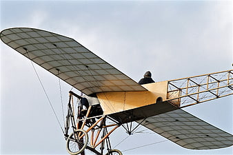 Vintage Biplane Replica in Flight Against Blue Sky